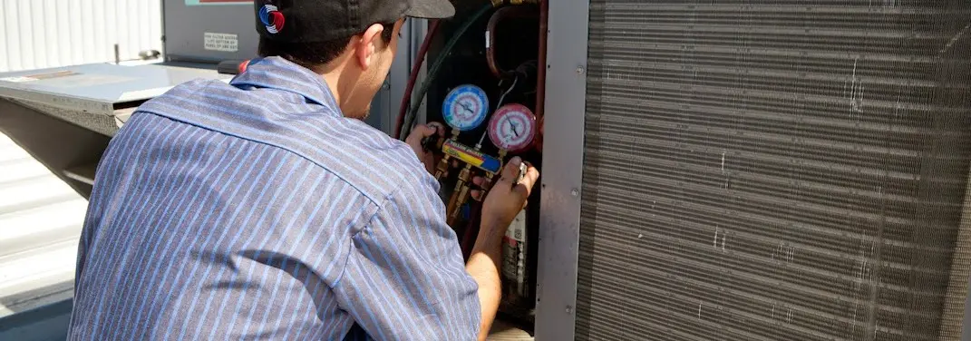 HVAC technician servicing a condenser unit in Dobbs Ferry